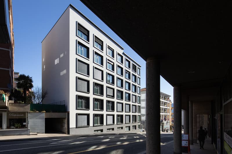 modern, 6 story building, white walls, garage, windows with blinds