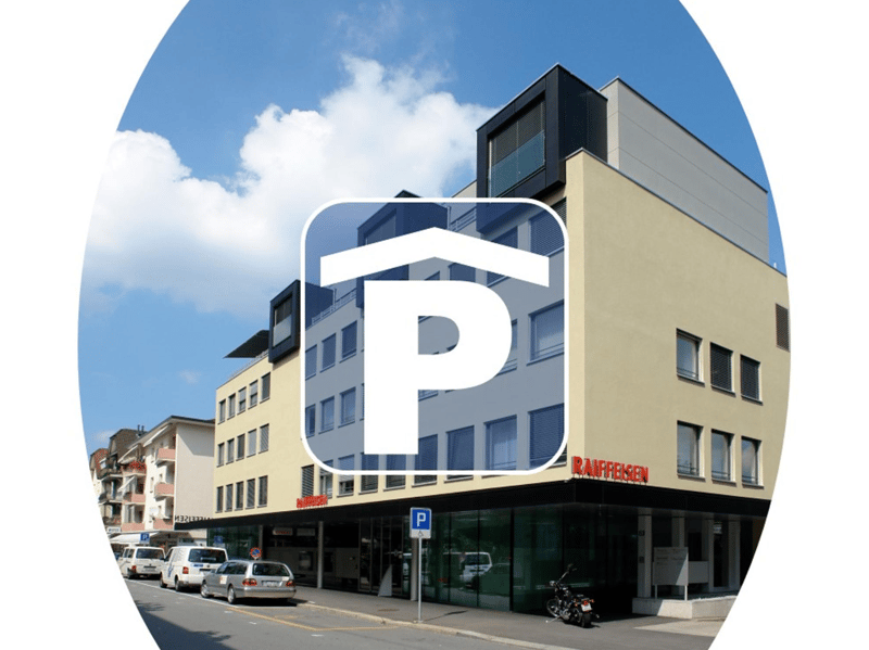 Multi-storey building with ground floor commercial space, several windows, parking sign, cars parked in front