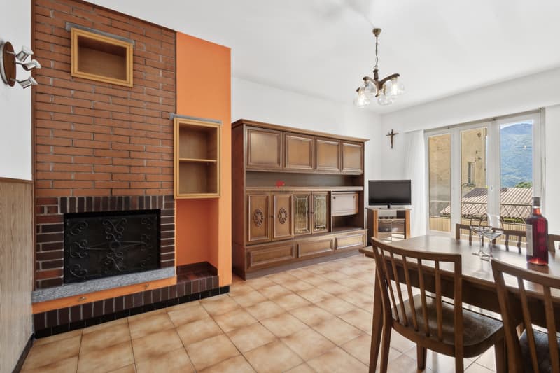 / Il soggiorno, che è direttamente accessibile dalla cucina come pure dall'atrio, si affaccia su un balcone e dispone di un grande camino.