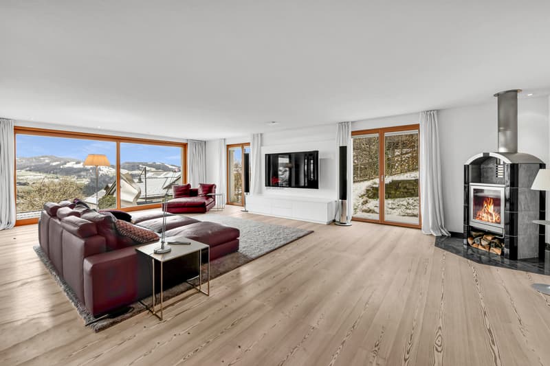 Gemütliches Wohnzimmer mit Kamin und traumhaftem Ausblick.
