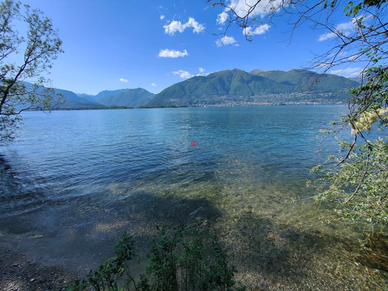 Am Ufer des Lago Maggiore: ein kleiner Badestrand gleich gegenüber vom Mehrfamilienhaus. / Nella spiaggia pubblica subito attraversando la strada dal condominio.
