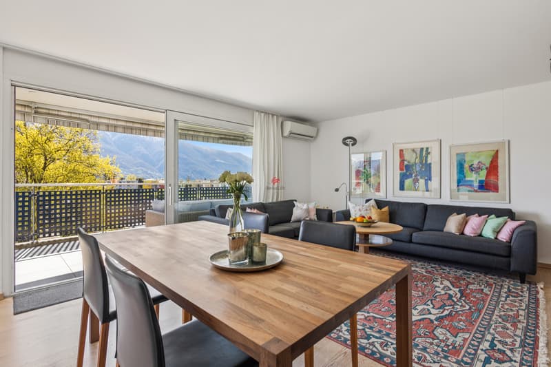 Klimatisiertes Wohnzimmer mit Blick über die Terrasse auf das Bergpanorama. / Soggiorno climatizzato con vista sulla terrazza e sul panorama montano