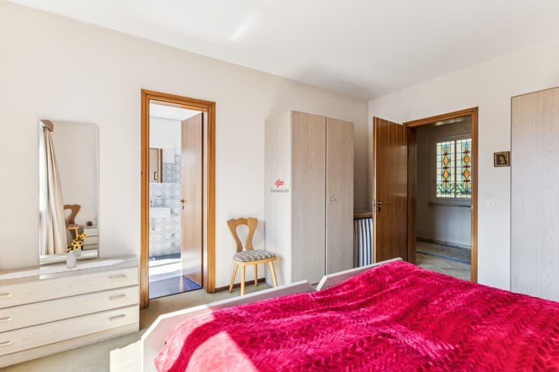 Schlafzimmer mit grossem En-Suite Badezimmer und Fenster zur Seeseite / Camera da letto con ampio bagno privato e finestra sul lago