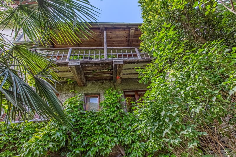 Der Anblick des Rustico vom Garten aus, mit dem Holzbalkon. / La vista del rustico dal giardino con il balcone in legno