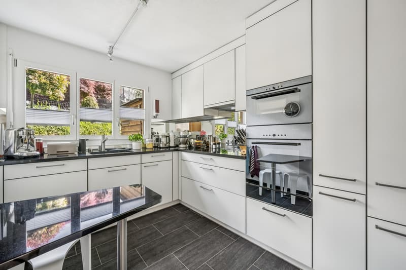 Separate Küche mit V-Zug Geräten und viel Stauraum. / a modern kitchen with white cabinets and stainless steel appliances