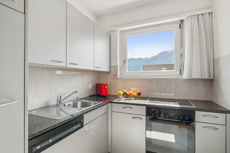Die Küche ist gut ausgestattet und bietet einen Panoramablick auf die Bergkulisse. / La cucina è ben attrezzata e offre una vista panoramica sul paesaggio montano
