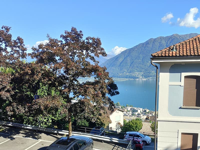 Vom Wohnzimmer und dem davorliegenden Balkon springen der Lago Maggiore und die Berge des Gambarogno ins Auge. / Dal soggiorno e dal suo balcone antistante si gode di una vista sul Lago Maggiore e sul