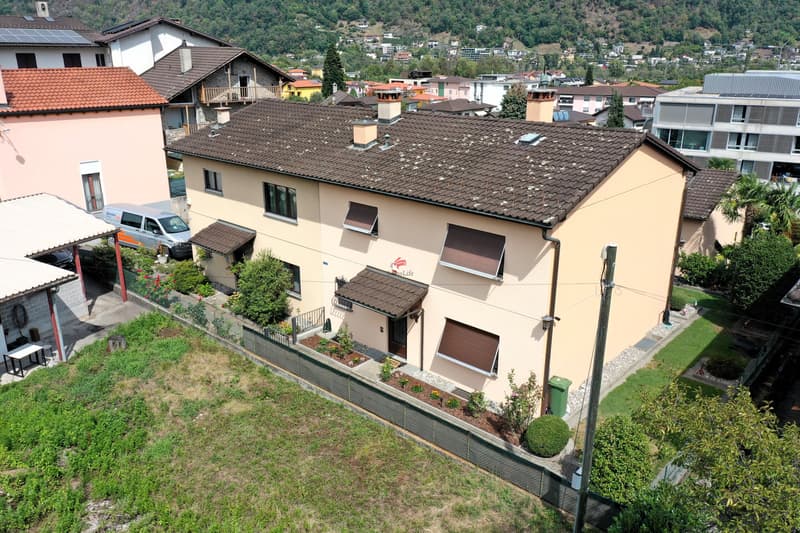 Von der Strasse und den Parkplätzen aus gelangt man zur ersten Haushälfte / Dalla strada e dai posteggi si accede alla prima metà della casa.