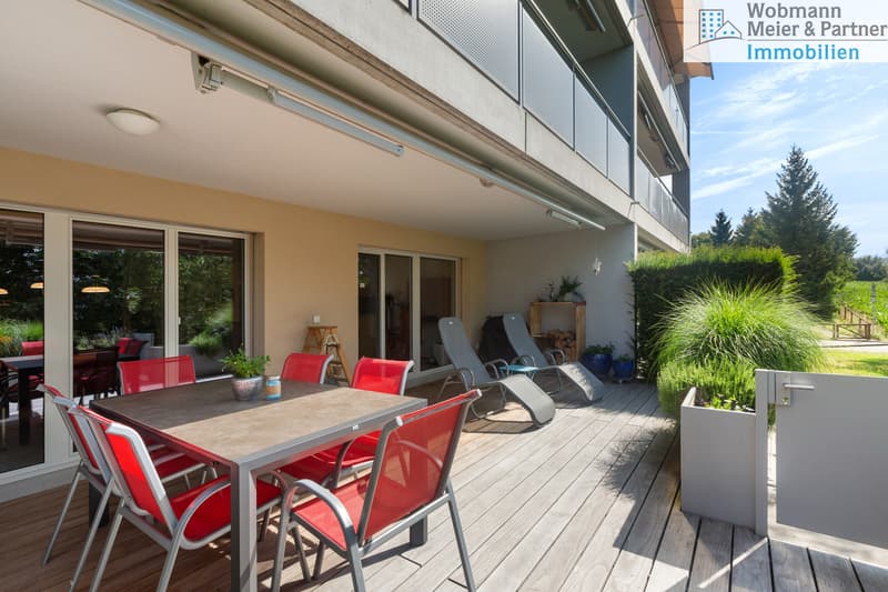 Sonnige Terrasse (25 m2, grossteils gedeckt) umgeben von üppigem Grün