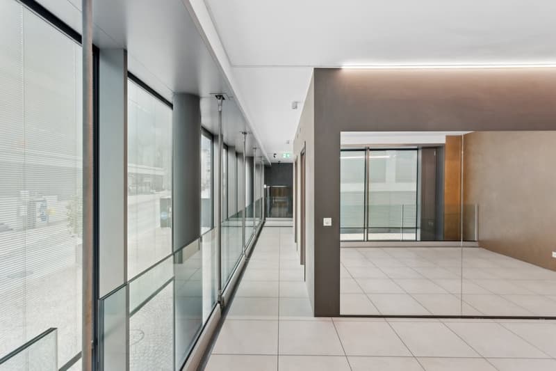 modern corridor, large glass windows, tiled flooring, metal beams, bright