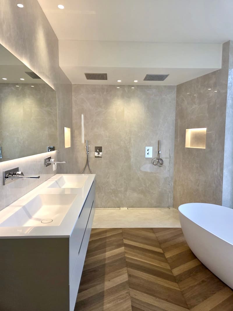 modern design bathroom with double sink, walk-in shower, bathtub, herringbone floor, mirrors, chrome fixtures