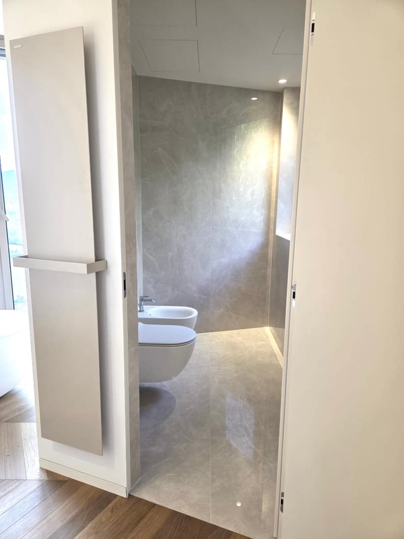 small bathroom, white walls, marbled floors, glass shower, white toilet, silver faucet