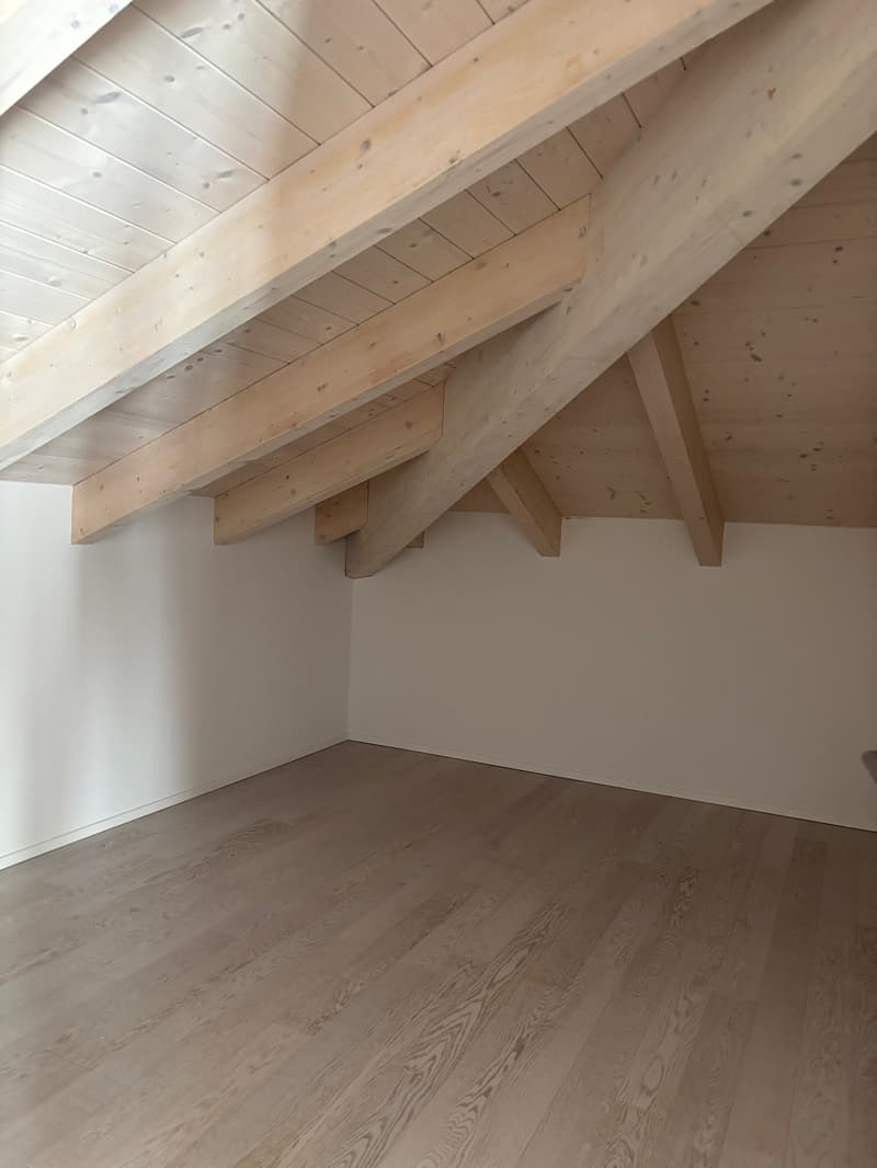 empty room with wooden beams ceiling, wooden floor