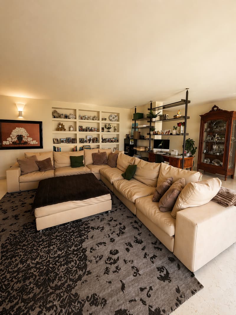 large L-shaped sofa, ottoman, carpet, shelves, desk, computer, cabinet, painting