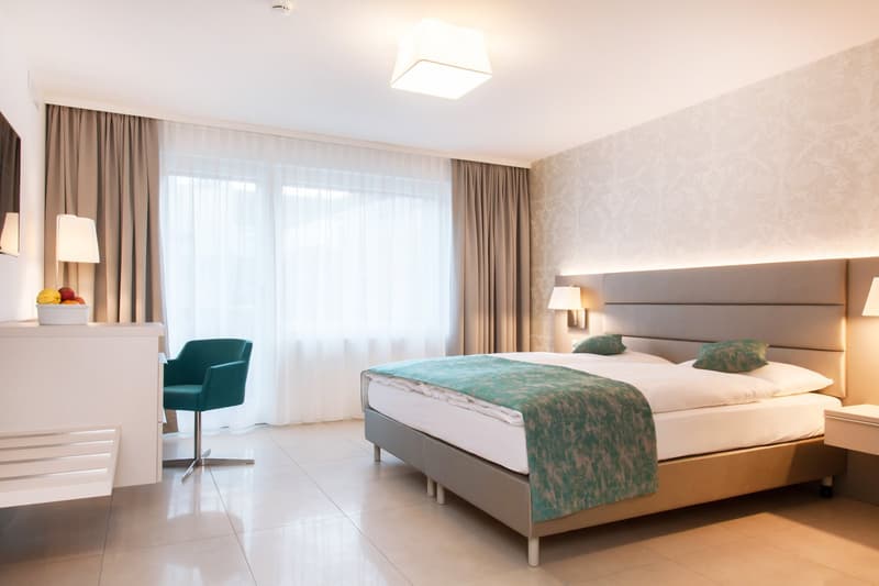 bed, pillows, blanket, desk, chair, lamp, TV, curtain, tiled floor, nightstand