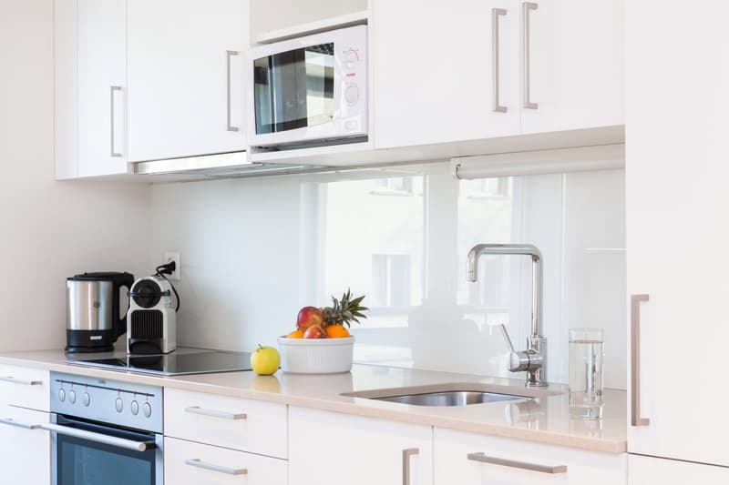 white kitchen with all appliances, countertop with stove, sink and appliances