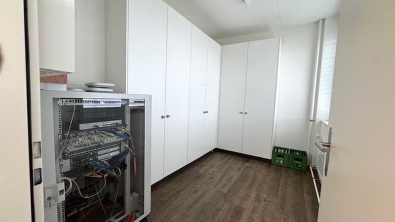 White walls, wooden floor, built-in cabinets, dishwasher