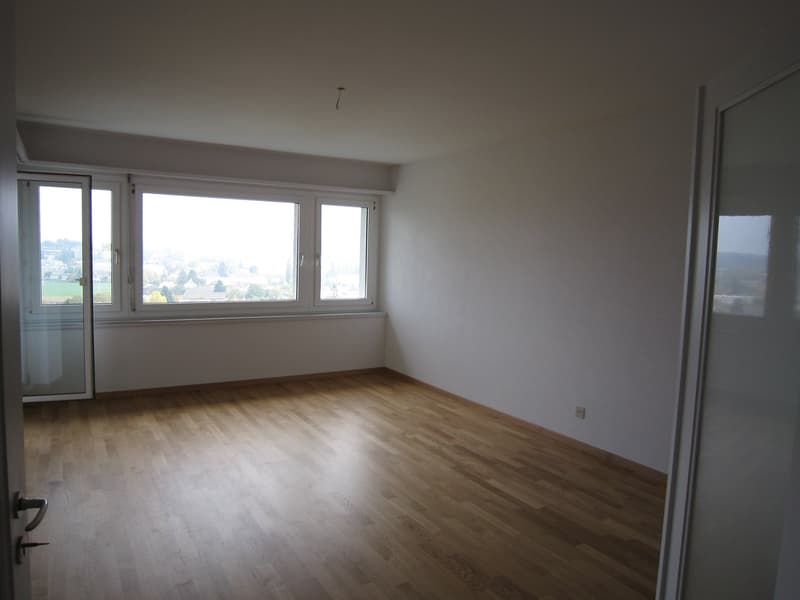 empty room, wooden floor, large windows, white walls, power outlet