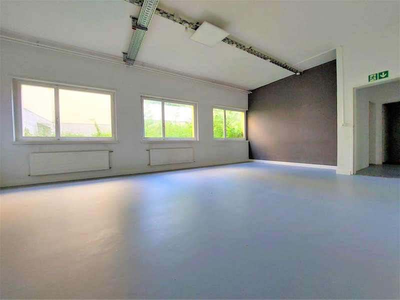 large empty room, white walls, white flooring, 3 windows, radiators