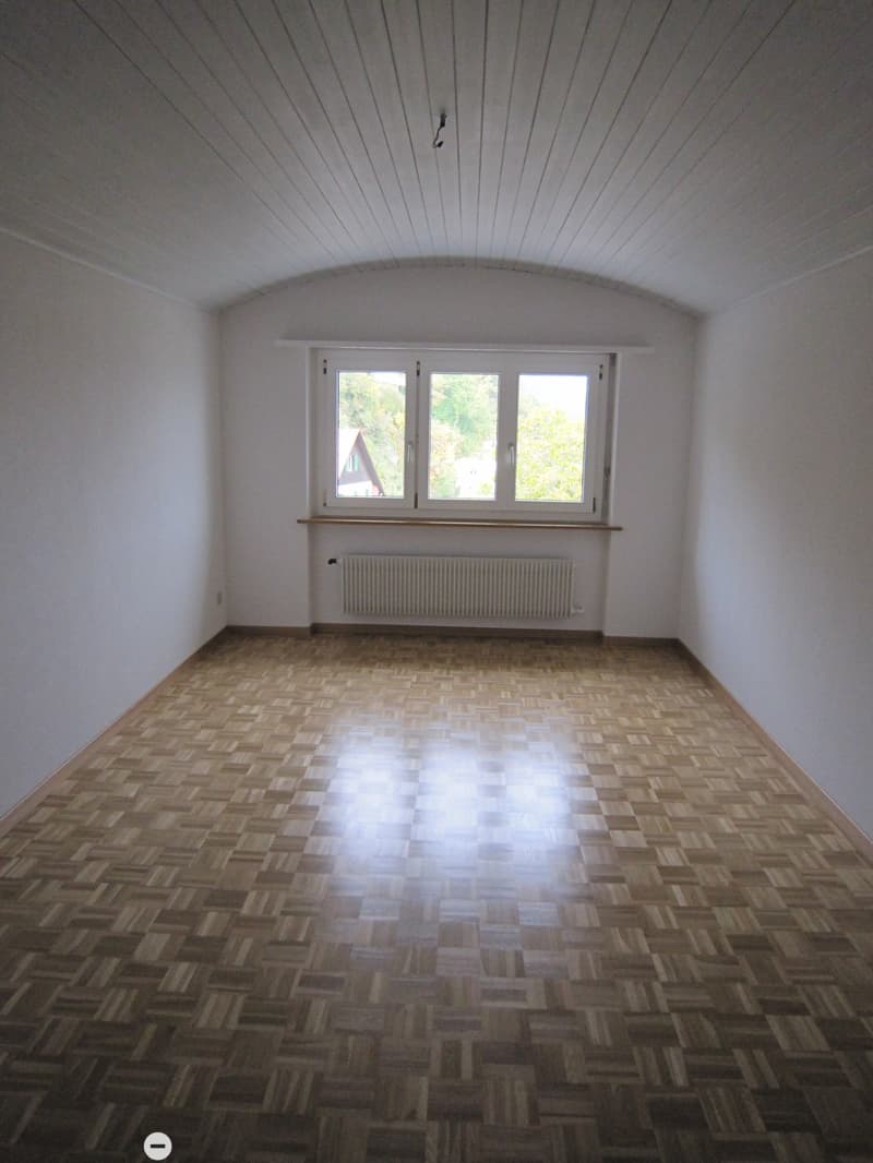 empty room, wooden parquet floor, white walls, large window, white radiator