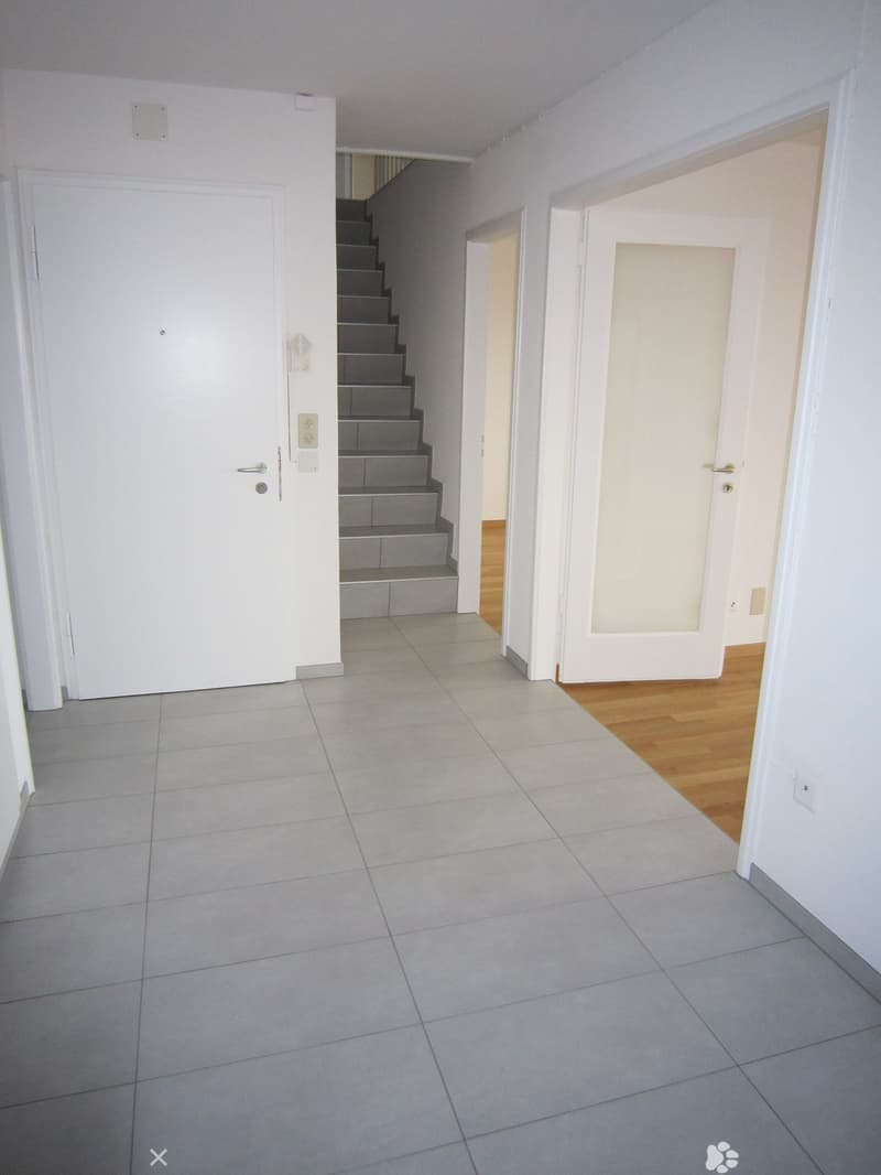 Empty room, white walls, gray tiles, white doors, staircase