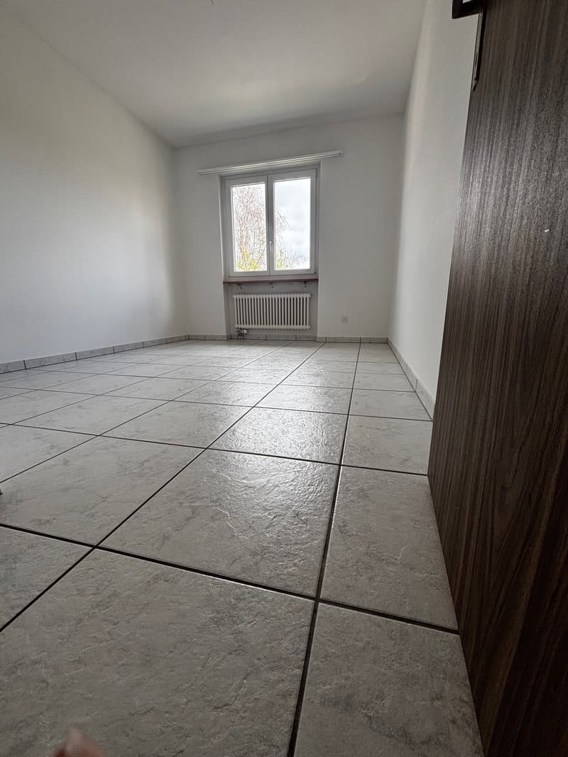 empty room, white walls, white tile floor, window with white frame, white radiator