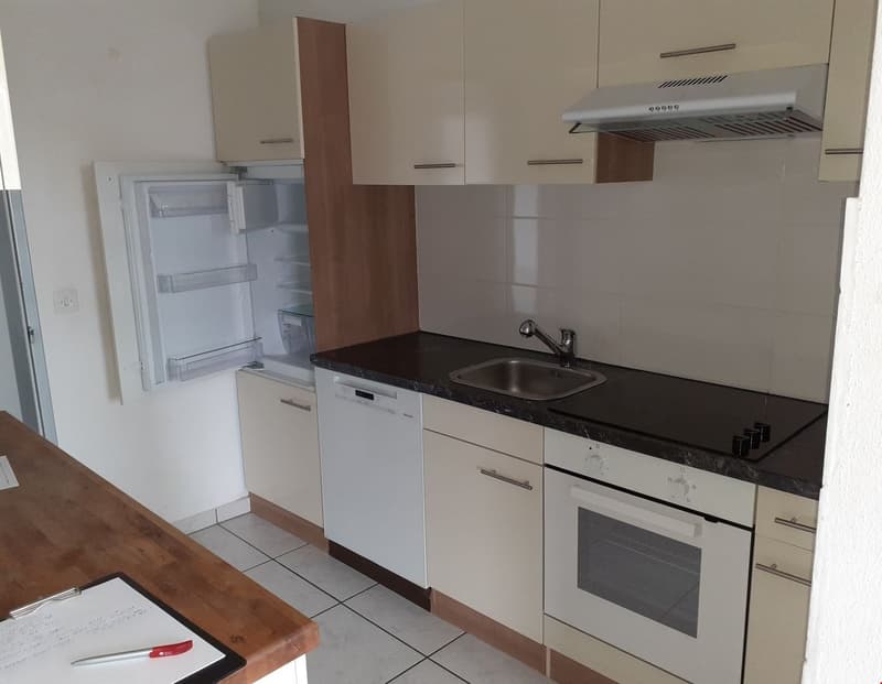 Modern kitchen with granite countertop, stainless steel sink, dishwasher, refrigerator, oven and stove.