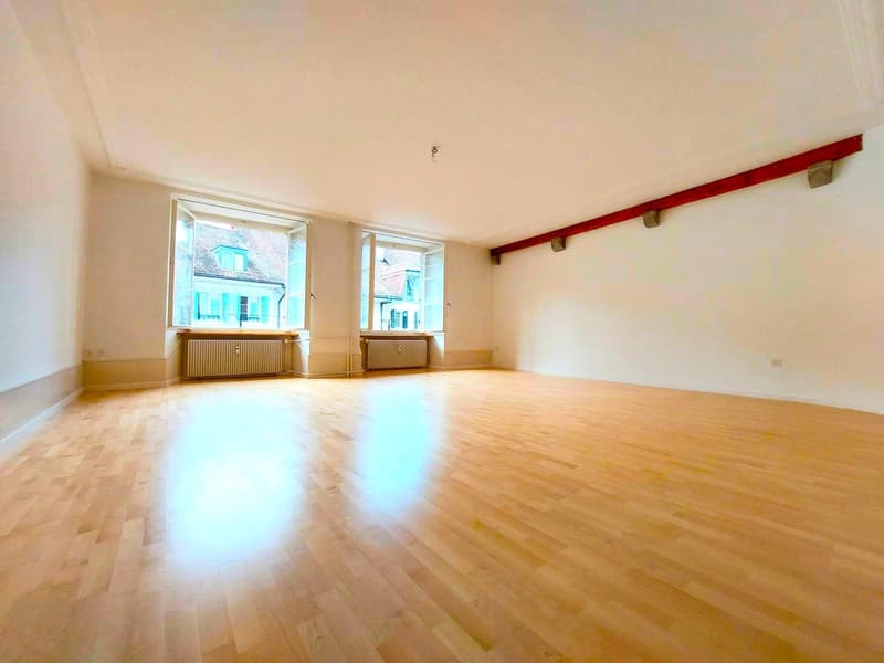 wooden floor, 2 large windows, white walls, no furniture
