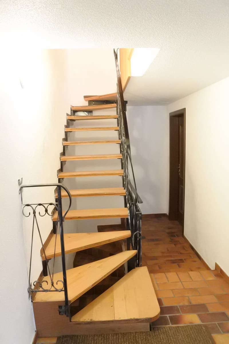 wooden steps, metal handrail, tiled floor, small window above the staircase