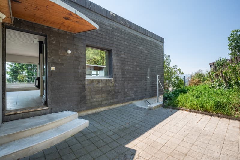 modern house, brick wall, glass door, concrete steps, paved entrance, window, outdoor light