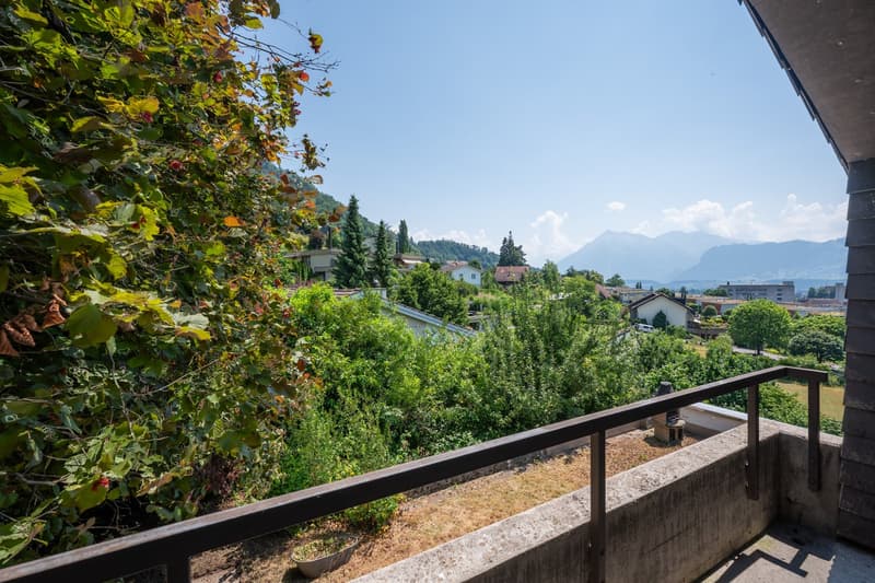 balcony with railing, view of the mountains, greenery
