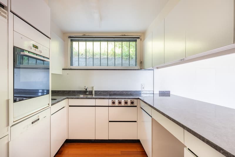 modern kitchen with white cabinets, granite countertops, stainless steel appliances, wooden floor
