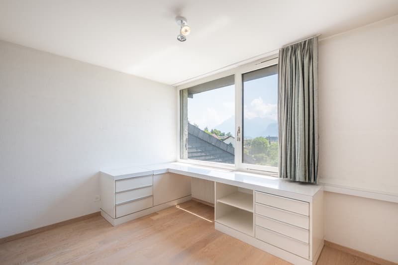 empty room, white walls, wooden floor, white desk, large window, curtain, ceiling lamp