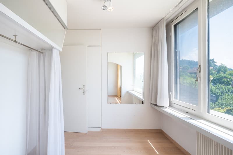 empty room, white walls, wooden floor, large window, mirror, white curtains