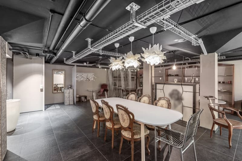 modern dining room with white table, wooden chairs, shelves, lamps, and tiled floor