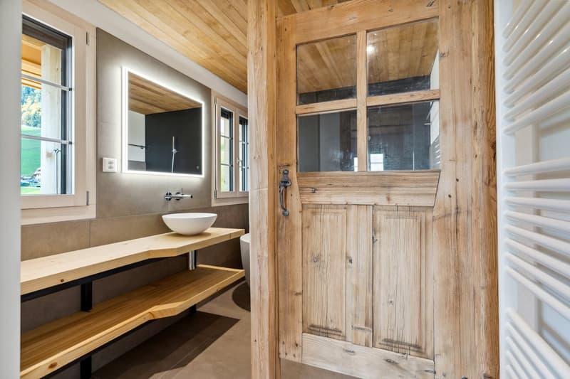 Bathroom with wooden shelves, white sink, wooden door, glass window, mirror, power outlet