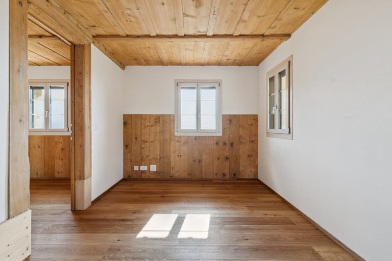 empty room with hardwood floors and wooden paneling on walls