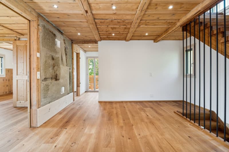 wooden floors, white walls, wooden beams, windows, open space