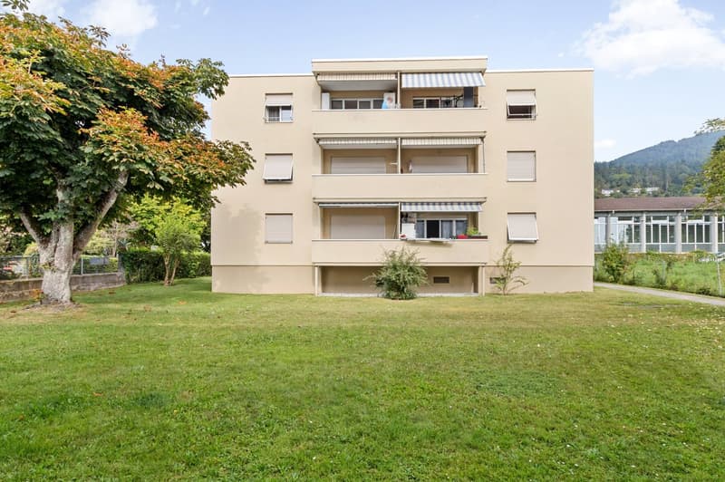 3-story building, beige exterior, multiple balconies, large lawn in front