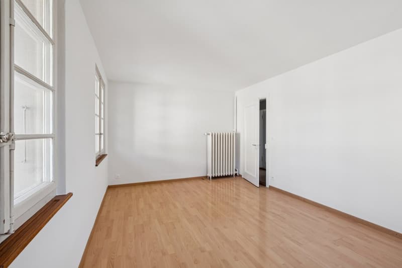empty room, wooden floor, white walls, windows, radiator