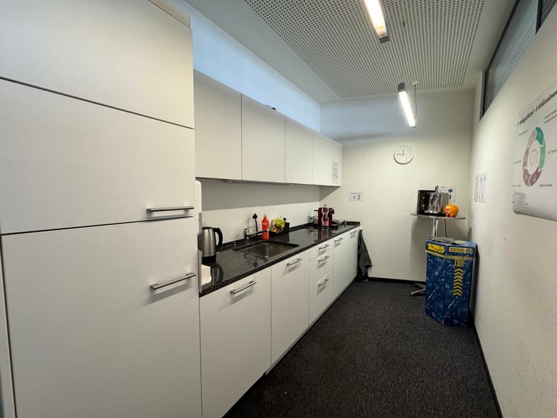 modern kitchen with white cabinets, black granite countertops, stainless steel sink, modern appliances, tiled floor, white walls, ceiling lights