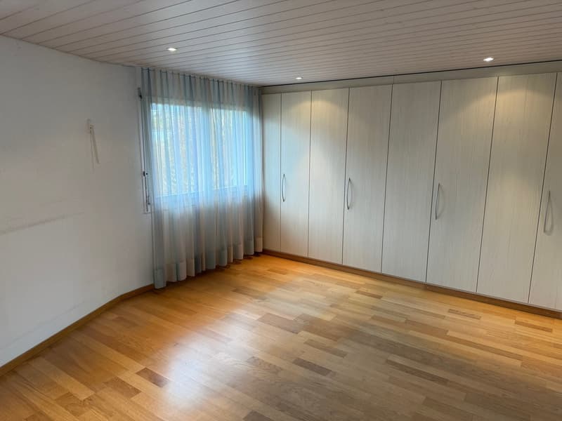 wooden floor, white walls, tall windows with white curtains, built-in wardrobes with silver handles