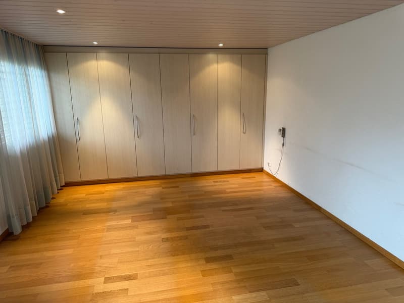 empty room, wooden floor, large built-in wardrobes, white walls, ceiling light, window with white curtain