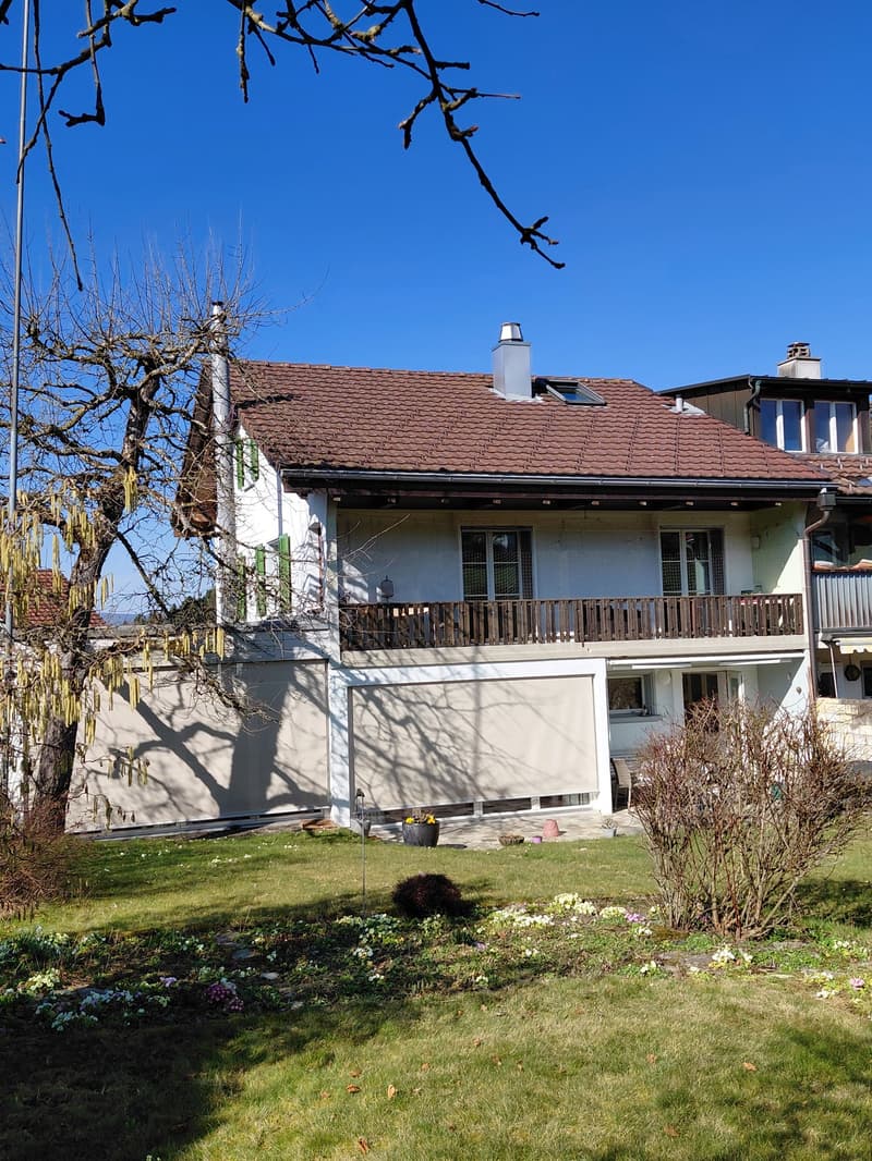 Two story house, white walls, brown roof, large balcony, garden, fence, chimney