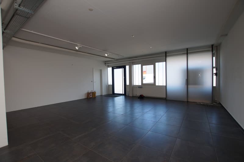 large empty room, tiled floor, white walls, recessed lighting, two doors, sliding door, glass windows