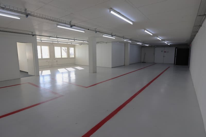 empty parking area, multiple lights, white walls, red markings