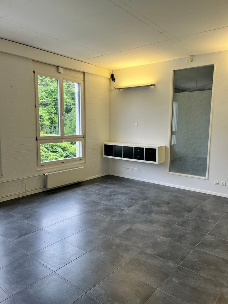 empty room, gray tiled floor, white walls, windows, small built-in heater, shelf with drawers