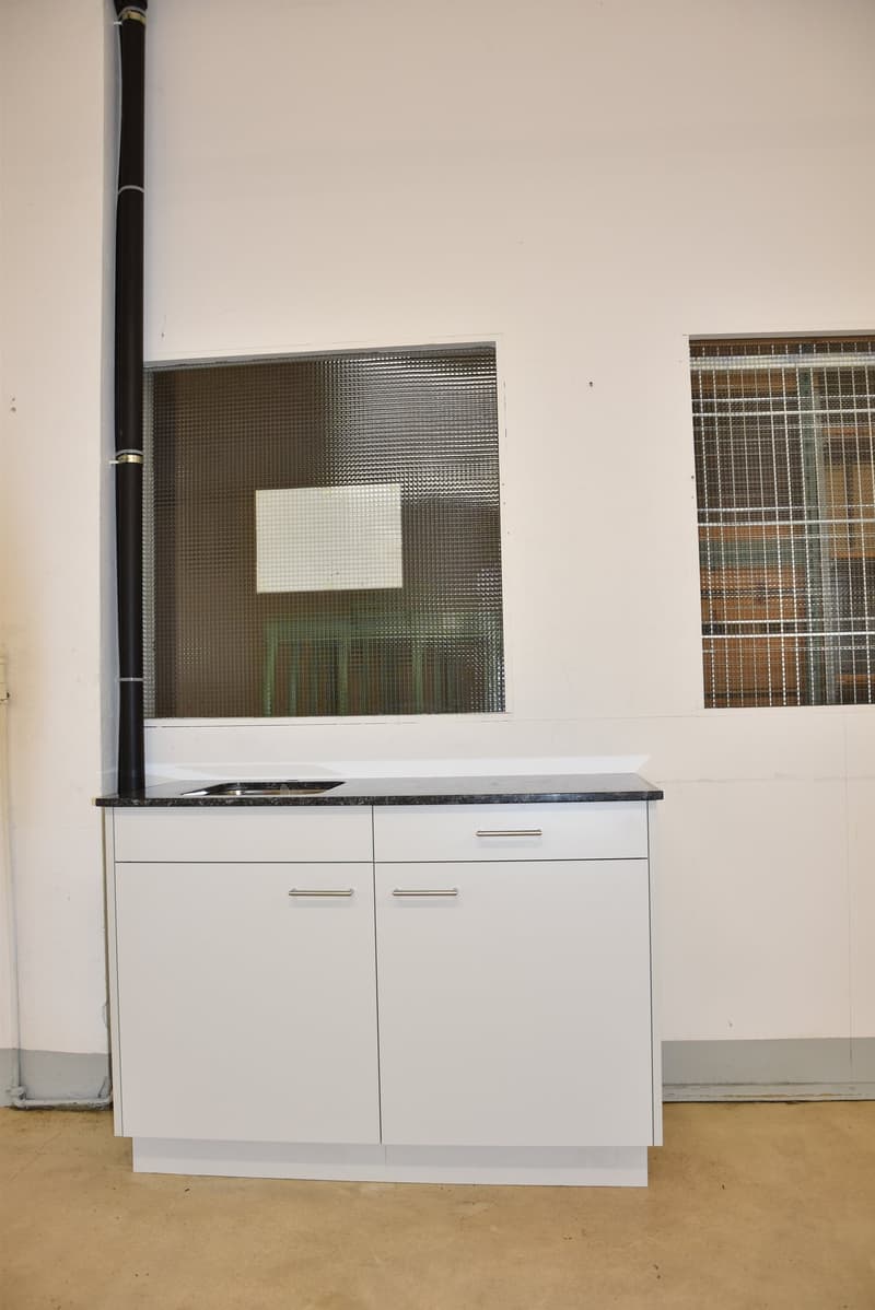 white cabinets with granite countertop, double stainless steel sink, two windows with bars