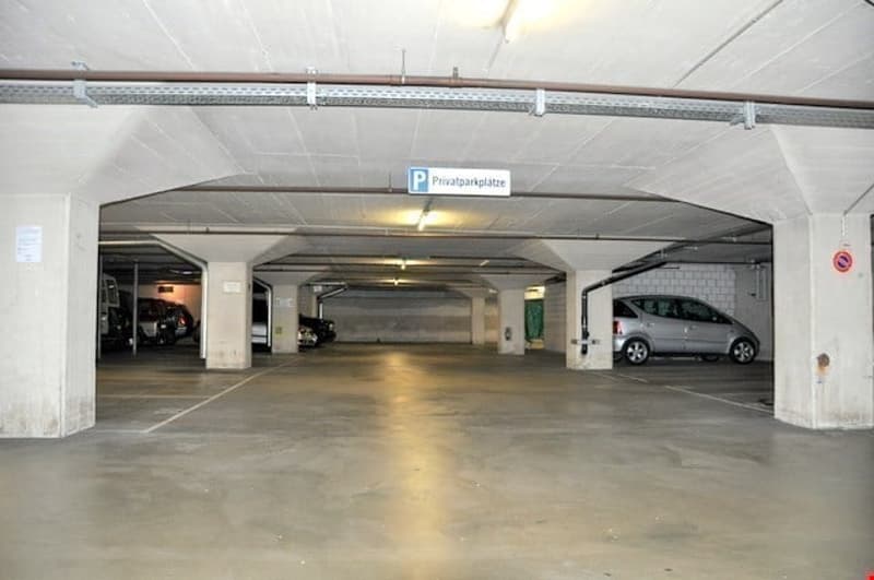 Underground parking garage with multiple parking stalls and private parking sign