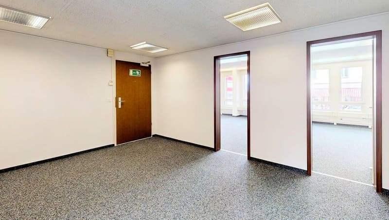 empty room with doors, windows, and ceiling lights